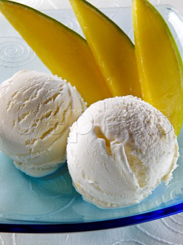 Two scoops of mango icecream with mango slices