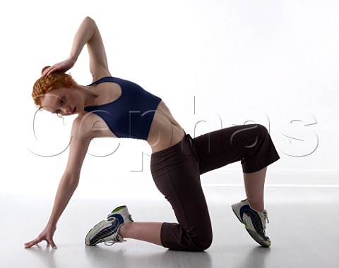 Young woman doing stretching exercises in a gym