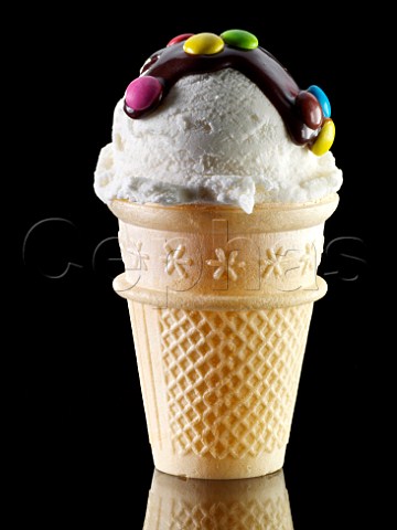Vanilla icecream cone with chocolate topping and Smarties