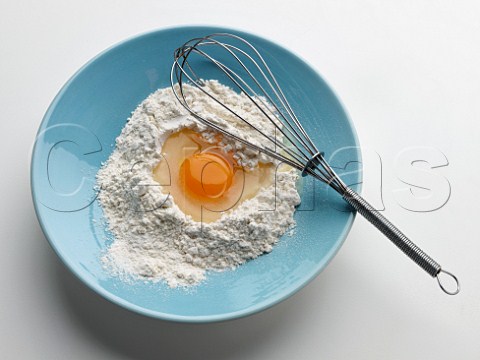 Egg and flour in mixing bowl with whisk