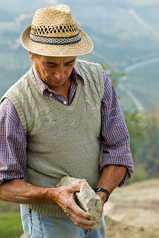 Giovanni Massolino holding a piece of calcareous marl rock typical of the region in vineyard of Massolino Serralunga dAlba Piemonte Italy Barolo