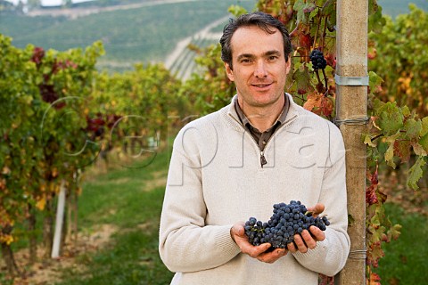 Franco Massolino holding Nebbiolo grapes in his Vigna Rionda vineyard Serralunga dAlba Piemonte Italy Barolo