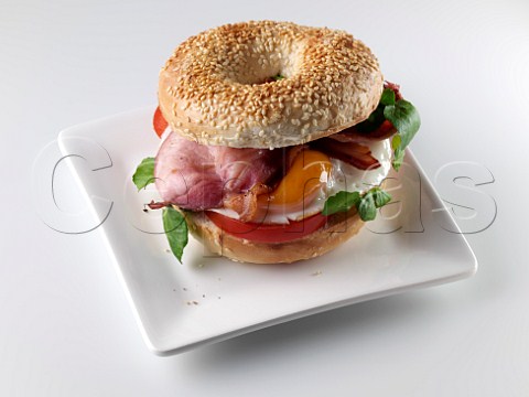 Breakfast bagel with fried egg bacon and tomato
