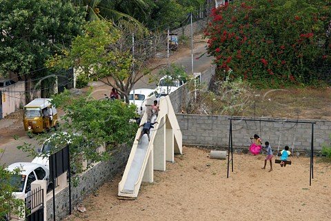 Children playing on the swings and slide in park Laxmana Nagar Kottivakkam Chennai Madras India