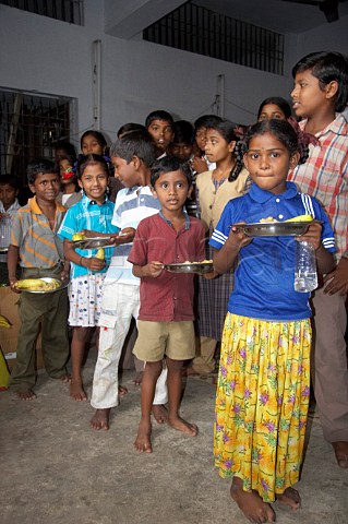 Indian children receice plates of food at the Compassion Ayanavaram Child Development Centre in the India Pentecostal Church of God IPC Thiruvalluvar Nagar Ayanavaram Chennai Madras India