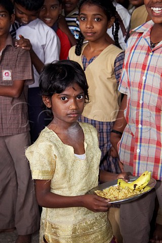 Young Indian girl with plate of food at the Compassion Ayanavaram Child Development Centre in the India Pentecostal Church of God IPC Thiruvalluvar Nagar Ayanavaram Chennai Madras India