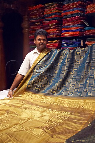 Indian man with luxury silk fabric in Pothys textile store Panagal Park TNagar Chennai Madras Tamil Nadu India