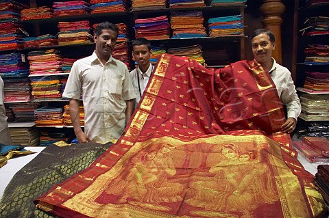 Indian men with luxury silk fabrics in Pothys textile store Panagal Park TNagar Chennai Madras Tamil Nadu India