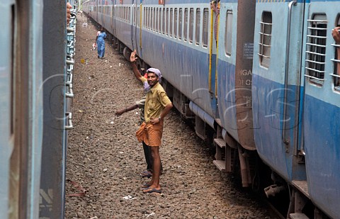Man standing between trains Enroute between Kochi Cochin and Kannur Cannanore Kerala India