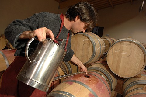 Topping up barriques with new wine in the cellar of Chteau Mazeyres  Pomerol Gironde France Pomerol  Bordeaux