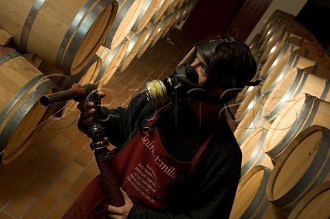 Filling barriques with new wine in the cellar of Chteau Mazeyres The mask is worn for protection against the fumes of sulphur which has been used to sterilise the barriques Pomerol Gironde France  Pomerol  Bordeaux