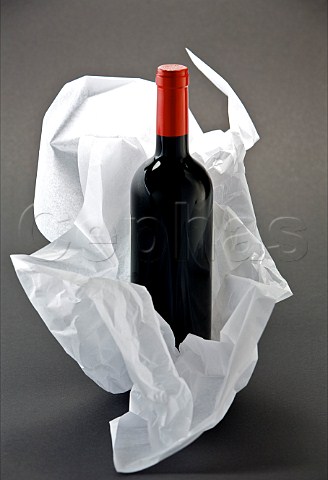 Bottle of red wine wrapped in tissue paper