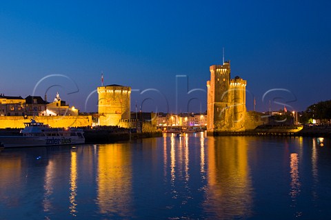 La Chaine and StNicholas towers at the entrance to the ancient port of La Rochelle at night CharenteMaritime France