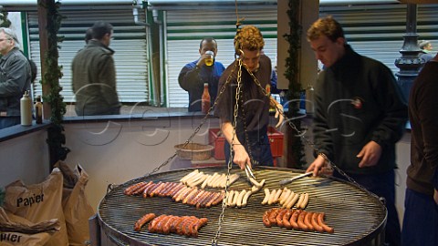 Cooking sausages at the German Christmas market in KingstonuponThames Surrey England