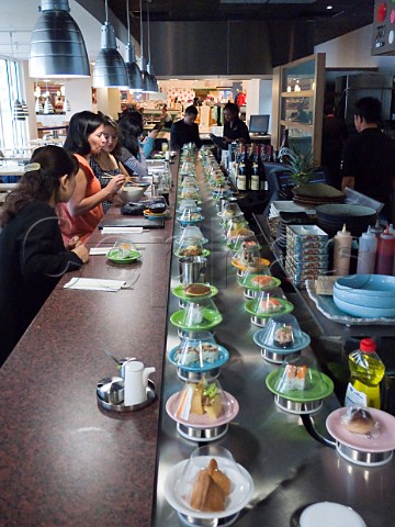 Sushi dishes on conveyor belt at Satori Sushi restaurant in Bentalls food hall KingstonuponThames Surrey