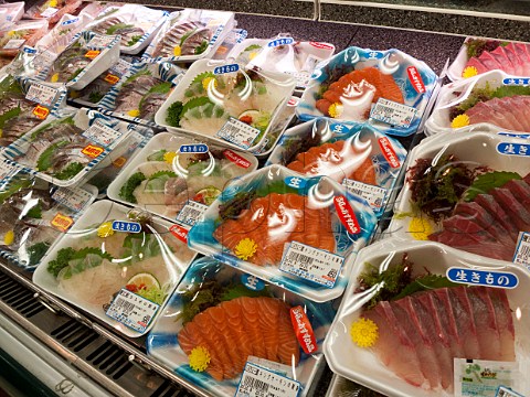 Trays of fresh fish prepared for sashimi on sale in a supermarket Oita city Japan