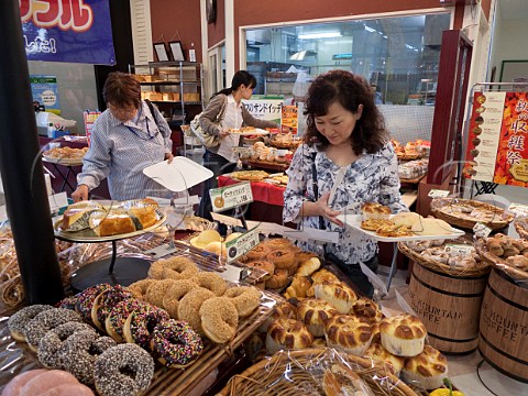 Japanese woman selecting various breads in a local supermarket Oita Japan