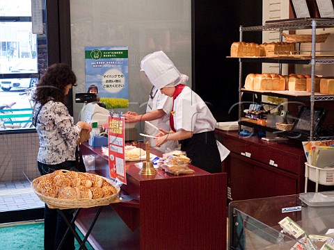 Japanese woman buying bread in a local supermarket Oita Japan