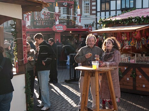 Couple with hot dogs and mulled wine at the German Christmas market in KingstonuponThames Surrey England