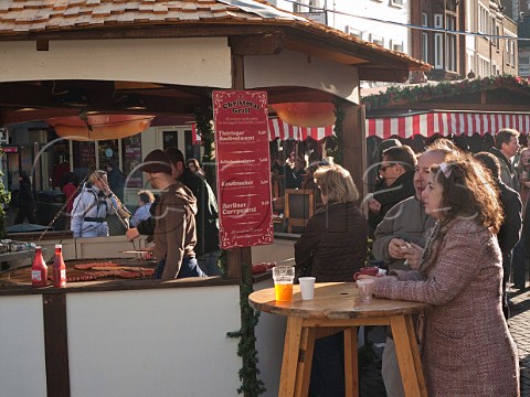 Couple with hot dogs and mulled wine at the German Christmas market in KingstonuponThames Surrey England