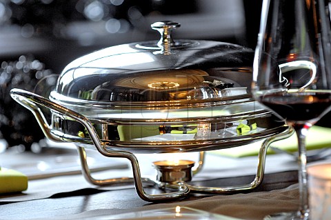Tealight heater under serving dish on restaurant dining table