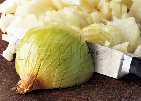 A kitchen knife chopping onions