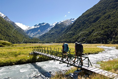 Hikers crossing bridge in West Matukituki River valley Mt Aspiring National Park South Island New Zealand