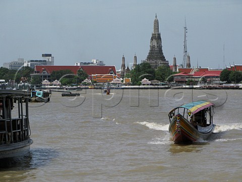 Water bus on Chao Phraya river with Wat Arun behind Bangkok Thailand