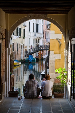 Two men looking at small canal Venice Italy