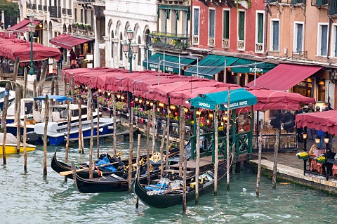 Restaurant seating and gondola moorings on the Grand Canal Riva del Vin Venice Italy