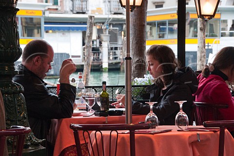 Open air restaurant seating overlooking the Grand Canal Riva del Vin Rialto Venice Italy