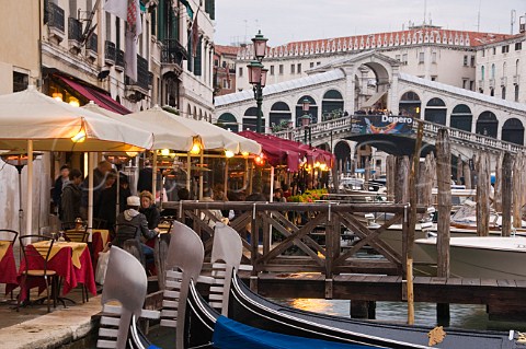 Gondolas moored at Riva del Vin with Rialto bridge beyond San Polo Venice Italy