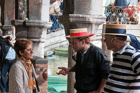 Woman talking with Gondoliers Campo dei Santi Apostoli Cannaregio Venice Italy