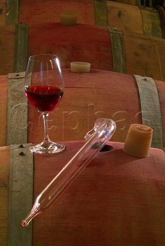 Glass of red Pinot Noir and pipette on oak barrel in Adelsheim Winery  Newberg Oregon USA  Willamette Valley