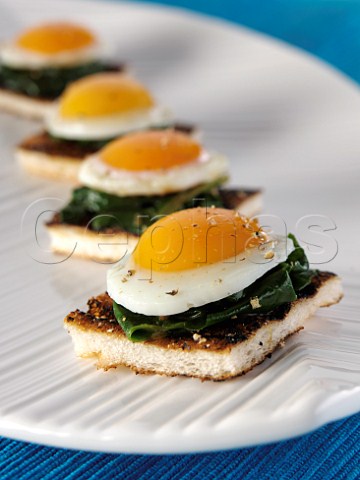 Peppered quails egg and spinach muffin canapes