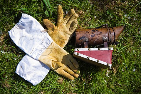 Beekeepers gloves and smoker in an orchard Sandford  North Somerset England
