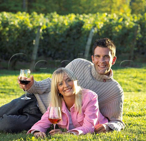 Young couple drinking wine in vineyard