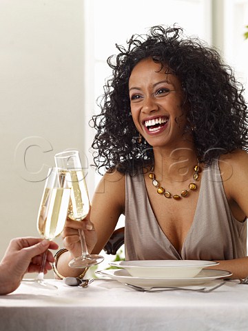 Young woman drinking glass of sparkling white wine in restaurant