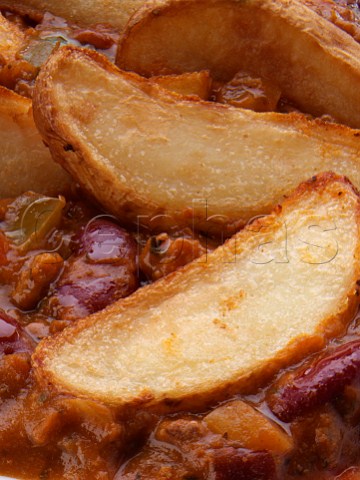 Chilli con carne and potato wedges close up