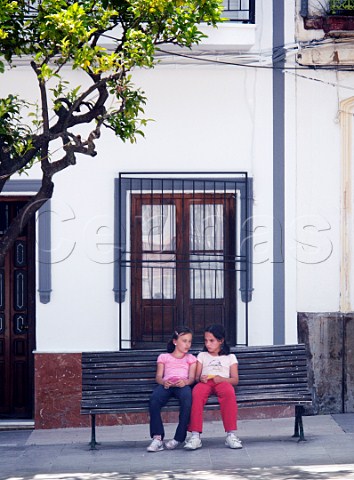 Young girls sitting on a bench in Ubrique Sierra de Cdiz Andaluca Spain