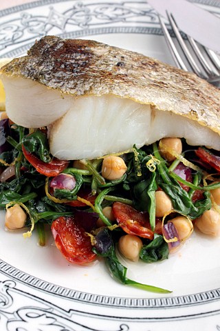 A baked fillet of pollack on a bed of garbanzo beans and spinach