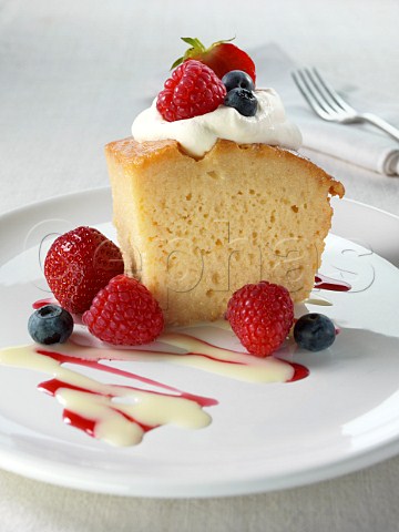 Spanish traditional sponge cake with evaporated and condensed milk topped with whipped cream and fruit