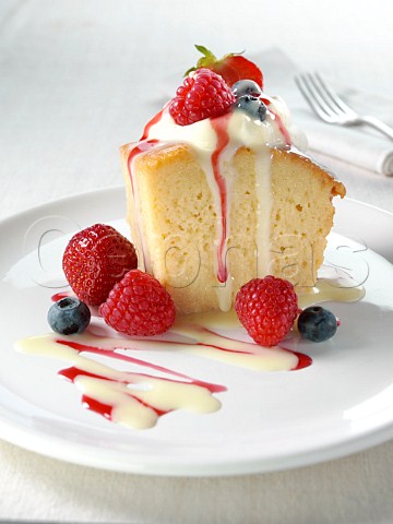 Spanish traditional sponge cake with evaporated and condensed milk topped with whipped cream fruit and coulis