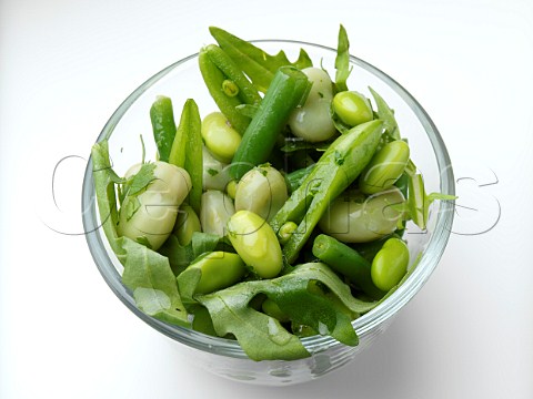 Green bean salad in a glass bowl on a white background