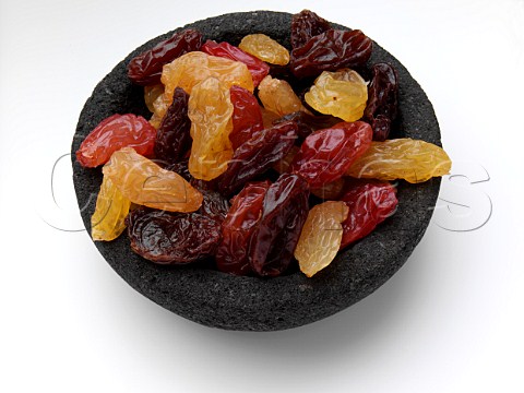 Jumbo sultanas and raisins in a black bowl on a white background