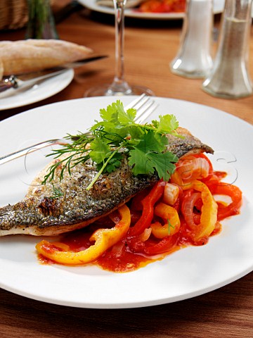 Sea bass and piperade in a restaurant table setting