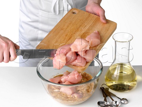 Adding chicken pieces to a marinade