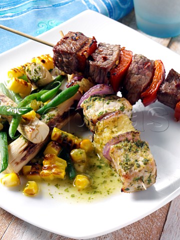 Pork and pineapple and chilli beef kebabs with corn and palm heart salad