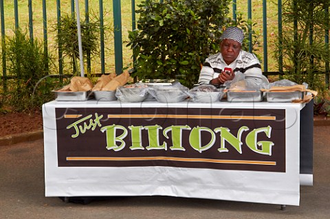 Woman texting on her mobile phone whilst selling Biltong at a roadside stall  Amanzimtoti KwaZuluNatal South Africa