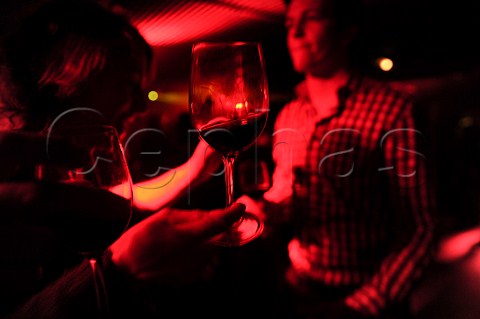 People holding glasses of red wine at a party